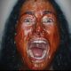 Woman covered in blood screaming into the camer